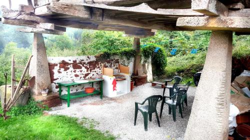 un patio con mesa y sillas bajo un puente en Apartamentos Villar, en Villar