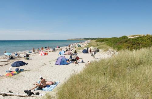 a group of people sitting on a beach at Ristinge Ferielejligheder in Humble