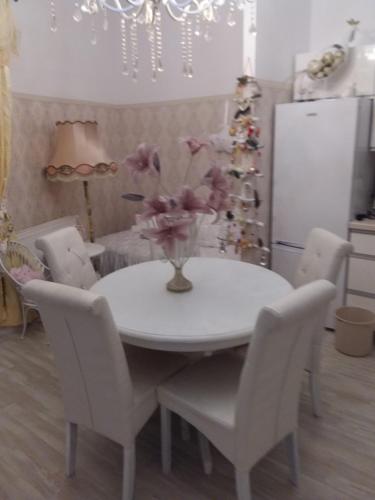 a white table with chairs and a vase of flowers on it at Marea20 in Międzyzdroje