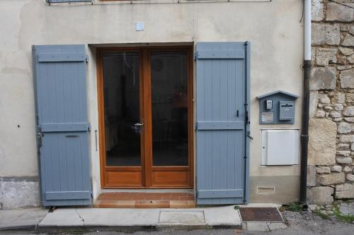 une porte avec volets bleus devant un bâtiment dans l'établissement Studio 1407 Arles - Proche Tour Luma, à Arles