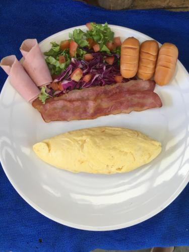 een wit bord met ontbijtproducten op tafel bij Baan Rabieng Talay Homestayบ้านระเบียงทะเล โฮมสเตย์เกาะกูด in Ko Kood