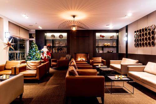 a living room with a christmas tree and couches at Hotel Nelson in Knokke-Heist