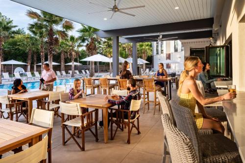 um restaurante com pessoas sentadas em mesas e uma piscina em Hotel Indigo Charleston - Mount Pleasant, an IHG Hotel em Charleston