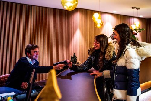 a man and woman sitting at a table shaking hands at Hotel Nelson in Knokke-Heist