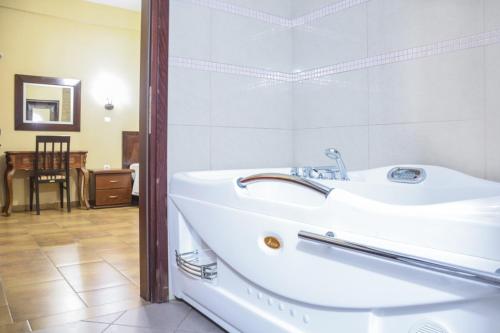 a bathroom with a white tub and a sink at Gea Kaimaktsalan Hotel & Spa in Kato Loutraki