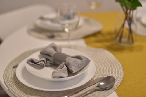 a table with a white plate with a napkin and silverware at Királykút 1 apartman - ingyen parkolás, bicajok, ac in Székesfehérvár