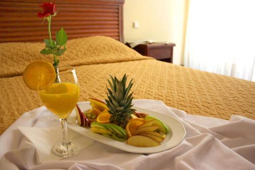 a plate of fruit and a glass of orange juice on a table at Xenia Hotel Drama in Drama