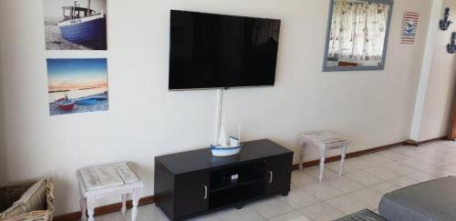 a living room with a flat screen tv on the wall at Stella Maris 142 in Amanzimtoti