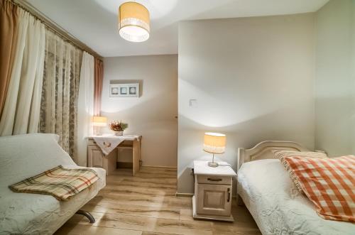 a small bedroom with two beds and a table at Dom Wypocz Pod Litwinką Apartamenty in Białka Tatrzanska