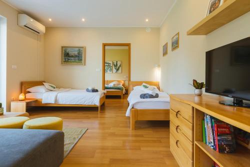 a living room with two beds and a flat screen tv at Apartmaji Koman in Bled