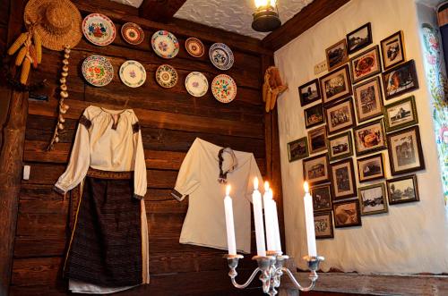 a room with a wall with plates and a dress and candles at Hotel Complex Legenda in Ivano-Frankivsʼk
