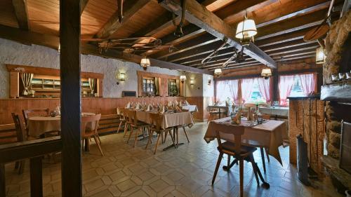 a restaurant with tables and chairs in a room at Hotel Restaurant Les Lilas in Les Diablerets