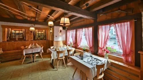 a restaurant with tables and chairs in a room with wooden walls at Hotel Restaurant Les Lilas in Les Diablerets