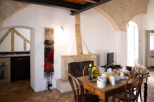 een eetkamer met een tafel en een open haard bij Hotel San Giorgio in Matera