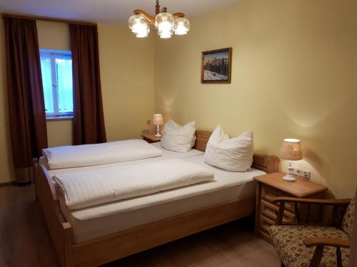 une chambre d'hôtel avec deux lits et une chaise dans l'établissement Haus Gasserer, à Berchtesgaden