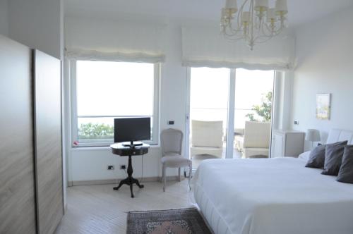 a bedroom with a bed and a desk with a computer at Maison Blanche Taormina in Taormina
