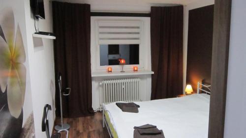 a bedroom with a bed and a window with candles at FeWo-Filter-Mölln in Mölln