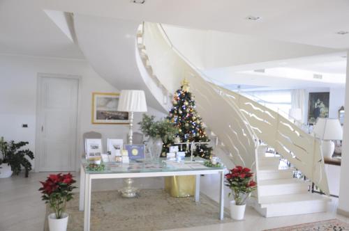 a christmas tree in a living room with a staircase at Maison Blanche Taormina in Taormina