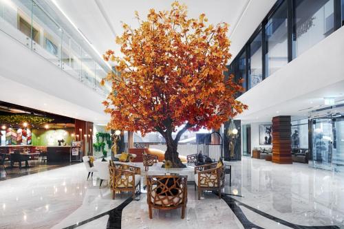 a tree filled with lots of flowers in front of a building at C Central Hotel and Resort The Palm in Dubai