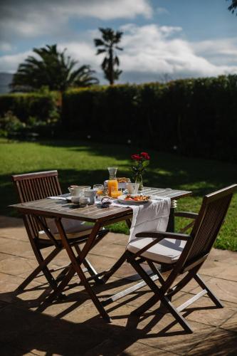a wooden table and two chairs with food on it at High Timbers Lodge in Tokai