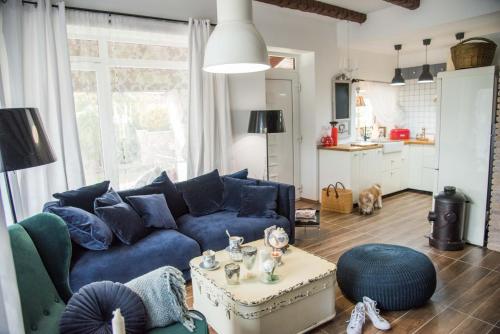 a living room with a blue couch and a table at Anita Home in Gyenesdiás