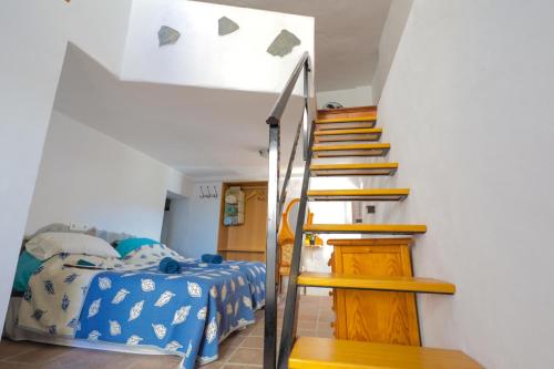 una escalera que conduce a un dormitorio con una cama en Casa Hadriano, en Cómpeta