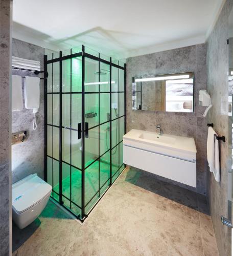 a bathroom with a glass shower and a toilet at Lalila Blue Suites in Marmaris
