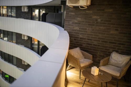 a room with chairs and a table and a brick wall at Pupin Palace Apartments in Novi Sad