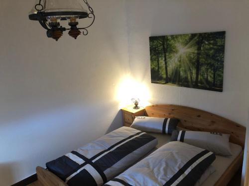 a bedroom with two beds and a light on the wall at Liebetrau Apartment in Gotha