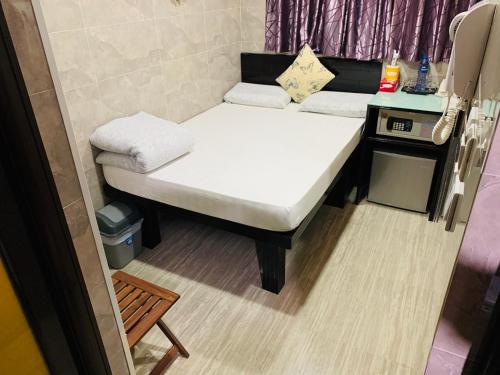 a small room with a small bed and a table at Victoria Inn in Hong Kong