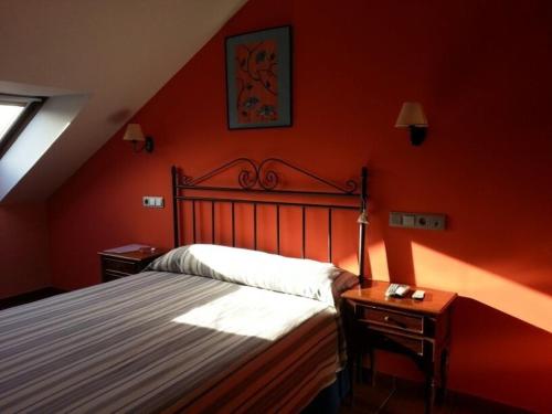 a bedroom with red walls and a bed and a window at Pension Arenas in Ajo