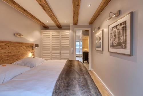 a bedroom with a large white bed with a wooden headboard at Herzbergs.Ferienwohnungen Meerfühlen in Scharbeutz