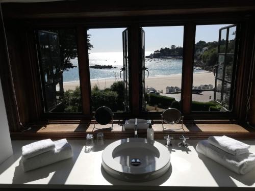 a bathroom with a sink and a view of the beach at Manoir Dalmore in Névez