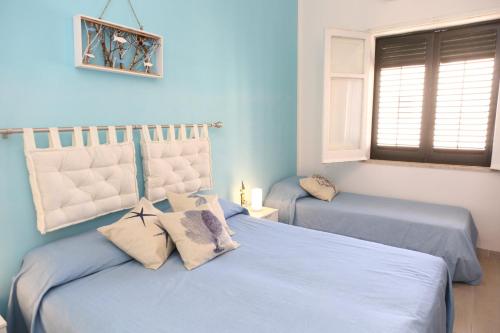 - 2 lits dans une chambre aux murs bleus dans l'établissement Terrazza Greco, à Cefalù
