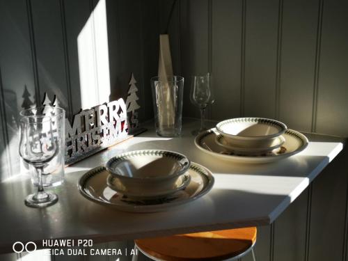 a table with two plates and glasses on it at Pen-Rhos luxury glamping "Cuckoo's Nest" in Llandrindod Wells
