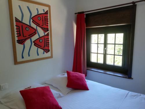 a bedroom with a bed with red pillows and a window at Manoir Dalmore in Névez