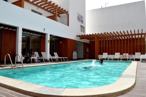 a pool in a building with a person in the water at Hotel Da Luz in Santa Maria