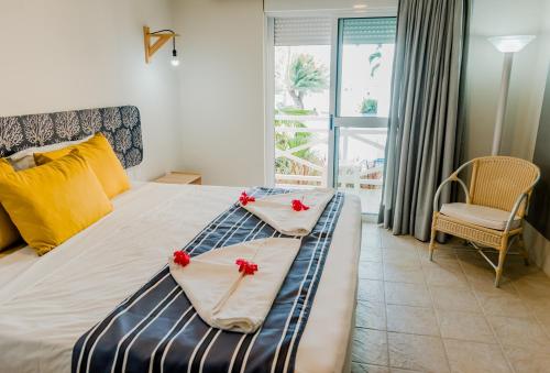 una camera da letto con un letto con fiori rossi di Baía Branca Beach Resort a Tamandaré