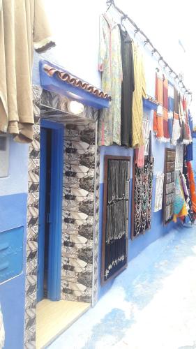a blue building with a bunch of clothes hanging up at Casa Lotfi in Chefchaouene