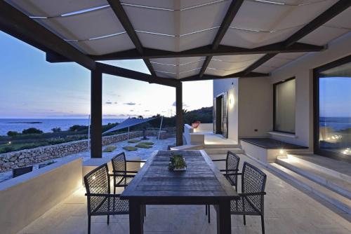an outdoor dining room with a table and chairs at Villa Pirreca in Favignana