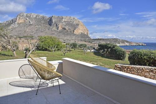 a chair on a balcony with a view of the ocean at Villa Pirreca in Favignana