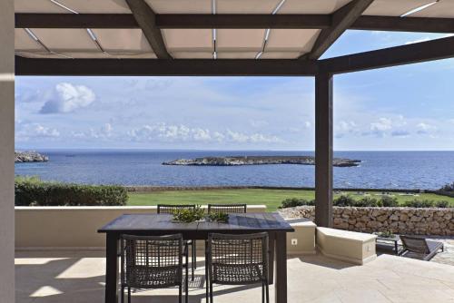 a patio with a table and chairs and the ocean at Villa Pirreca in Favignana