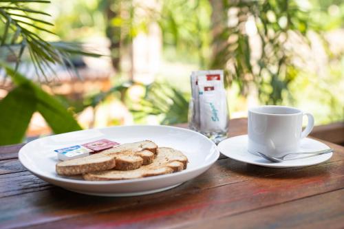 een bord brood en een kopje koffie op een tafel bij Green Space Villa in Ubud