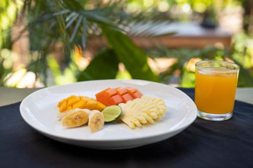 een schaal fruit en een glas sinaasappelsap bij Green Space Villa in Ubud