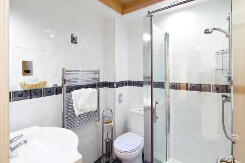a bathroom with a toilet and a glass shower at Queens Mansions: Ocean View Apartment in Blackpool