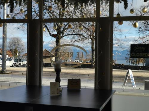 a table in front of a window of a store at L'Hôtel by Hostellerie du Château in Rolle