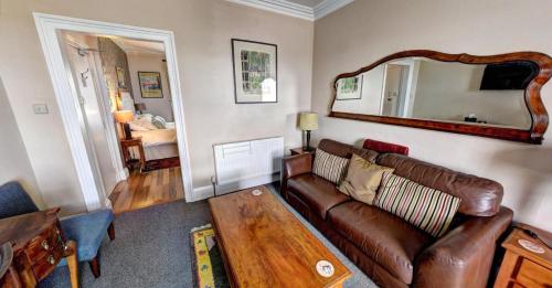 a living room with a couch and a mirror at Ascot House Hotel in Torquay