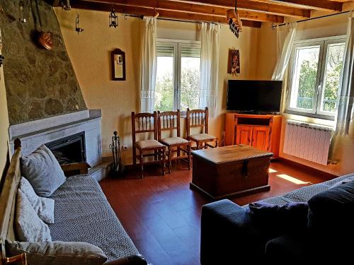 a living room with a couch and a tv at Casa Rural Las Chorreras in Navalguijo