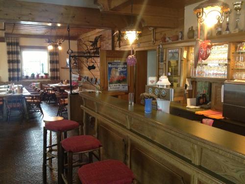 a bar in a restaurant with red stools at Alpengasthaus Sonnhof in Goding