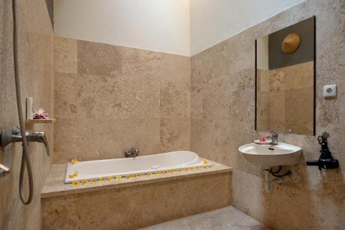 y baño con bañera y lavamanos. en Bidadari Villa, en Seminyak